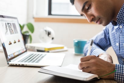 candidates takes notes while being interviewed virtually